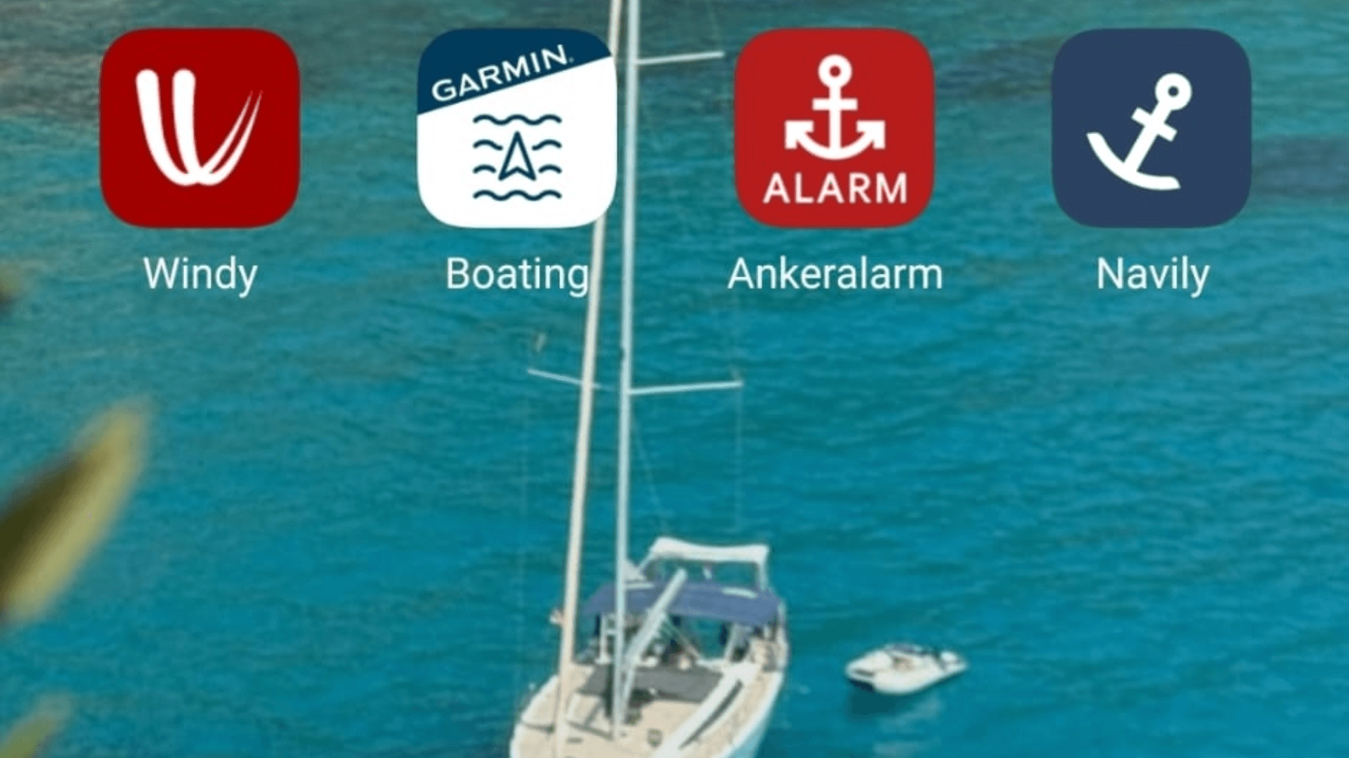 Smartphone mit den Apps Windy, Navionics, Ankeralarm und Navily auf dem Homescreen, zur Vorbereitung und Durchführung eines Segeltörns