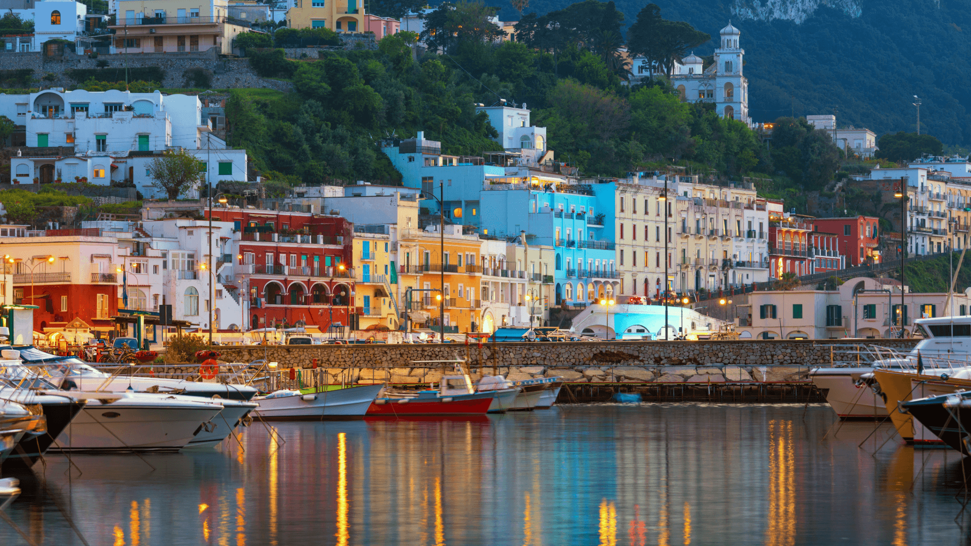 Blick auf den malerischen bunten Hafen von Capri – Segeln an der Amalfiküste mit pastellfarbenen Häusern und azurblauem Mee