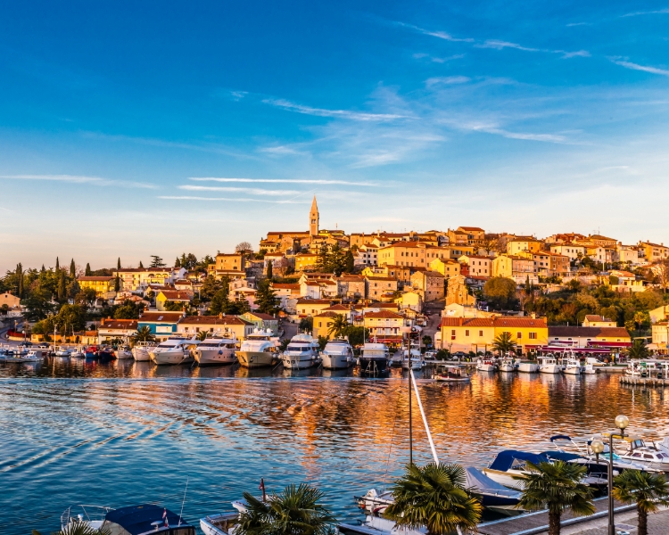 Blick auf die Altstadt von Vrsar in der Abendsonne mit Yachten in der Marina – Segelziel mit BlackSails-Yachting in Istrien, Kroatien