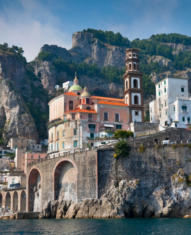 Blick auf die Stadt Amalfi mit farbenfroher Kirche und steiler Felsküste – idealer Stopp beim Yachtcharter mit BlackSails-Yachting entlang der Amalfiküste