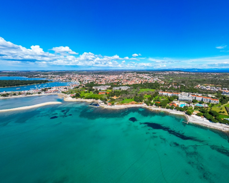 Luftaufnahme von Medulin und Pomer mit türkisblauem Wasser und grüner Küste – Rückkehrpunkt einer Segelreise mit BlackSails-Yachting in Istrien