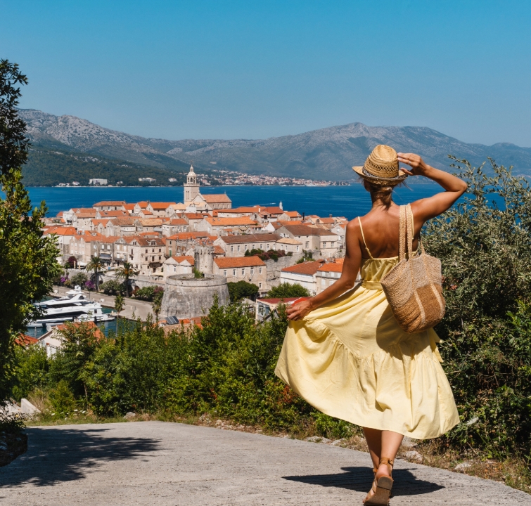 Frau in Sommerkleid blickt auf die Altstadt von Korčula – Segeltörn Süddalmatien mit BlackSails-Yachting