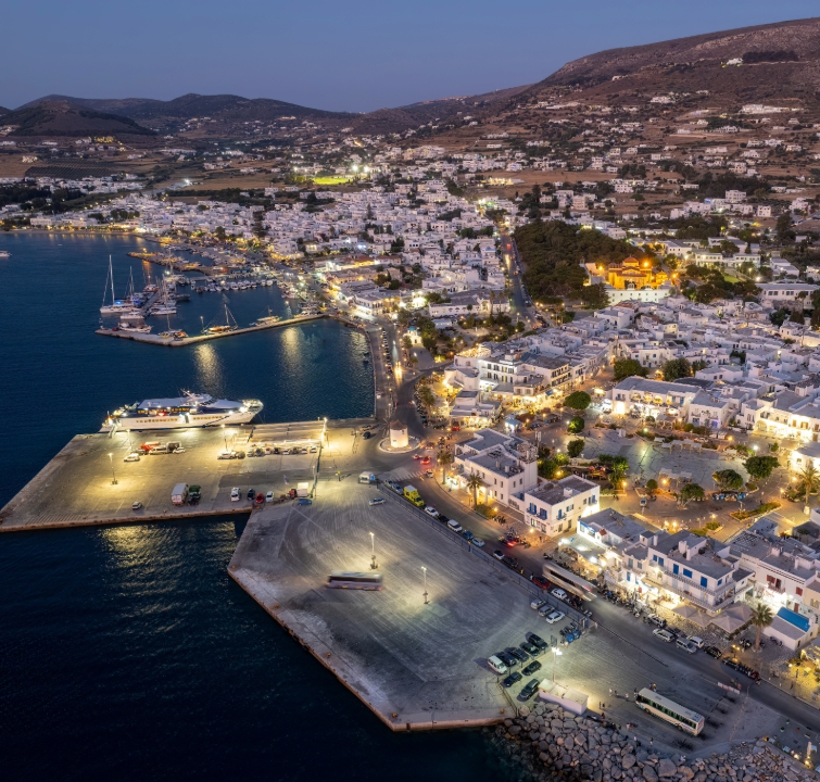 Luftaufnahme von Paroikia bei Nacht mit beleuchtetem Hafen und Marina – Endpunkt eines Kykladen-Yachtcharters mit BlackSails-Yachting