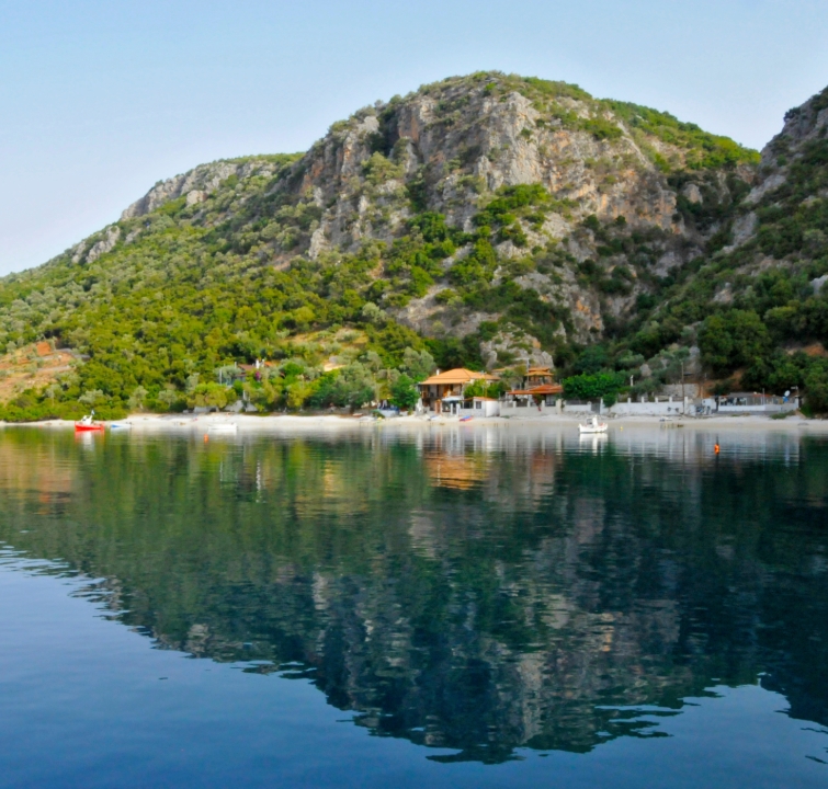 Versteckte Bucht mit Strand, Tavernen und dramatischer Felskulisse – idealer Ankerplatz beim Yachtcharter mit BlackSails-Yachting in den Sporaden.