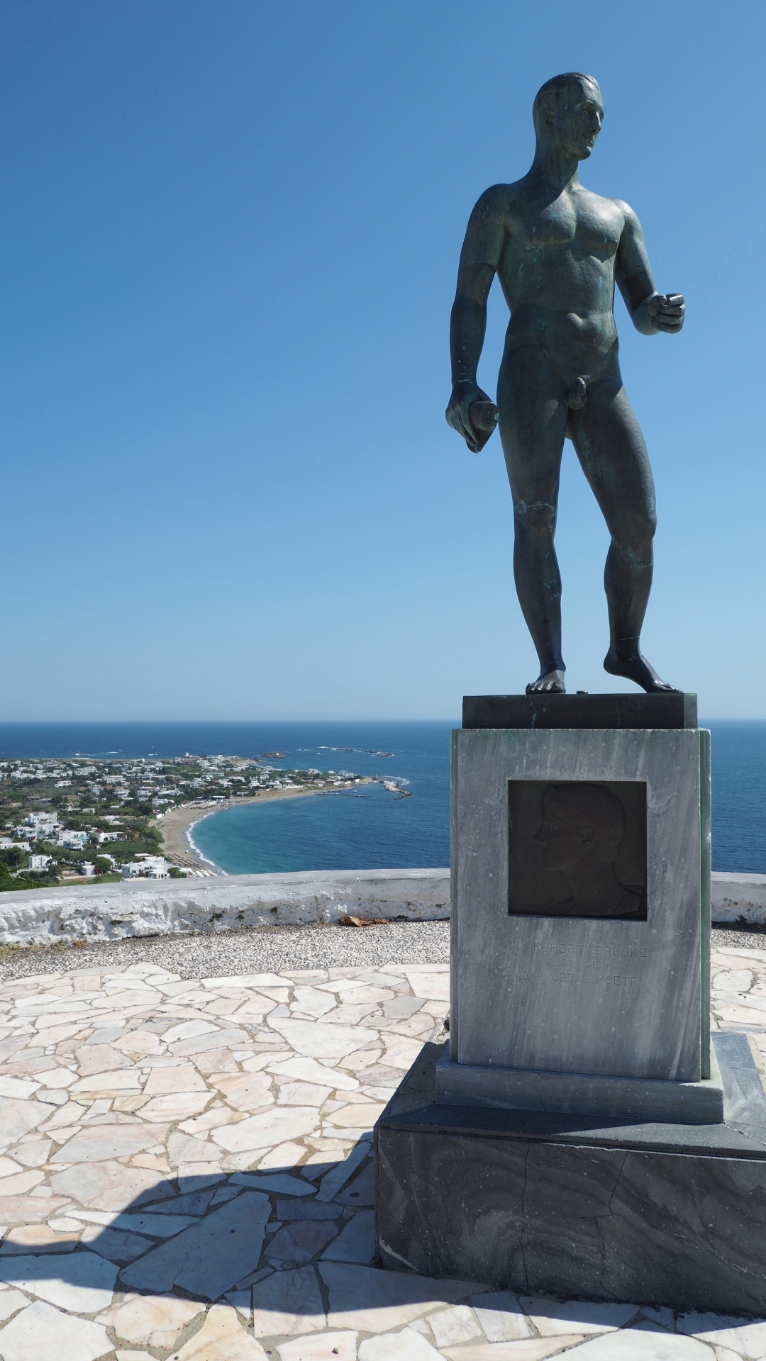 Sonnenaufgang über einem Küstenort der Sporaden mit Blick auf ruhiges Meer, Inselhügel und typische weiße Häuser.