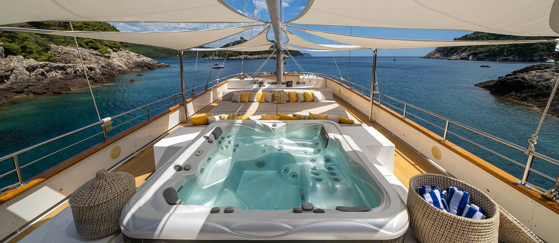 Jacuzzi an Deck der Dalmatino unter Sonnensegeln, dahinter eine Bucht