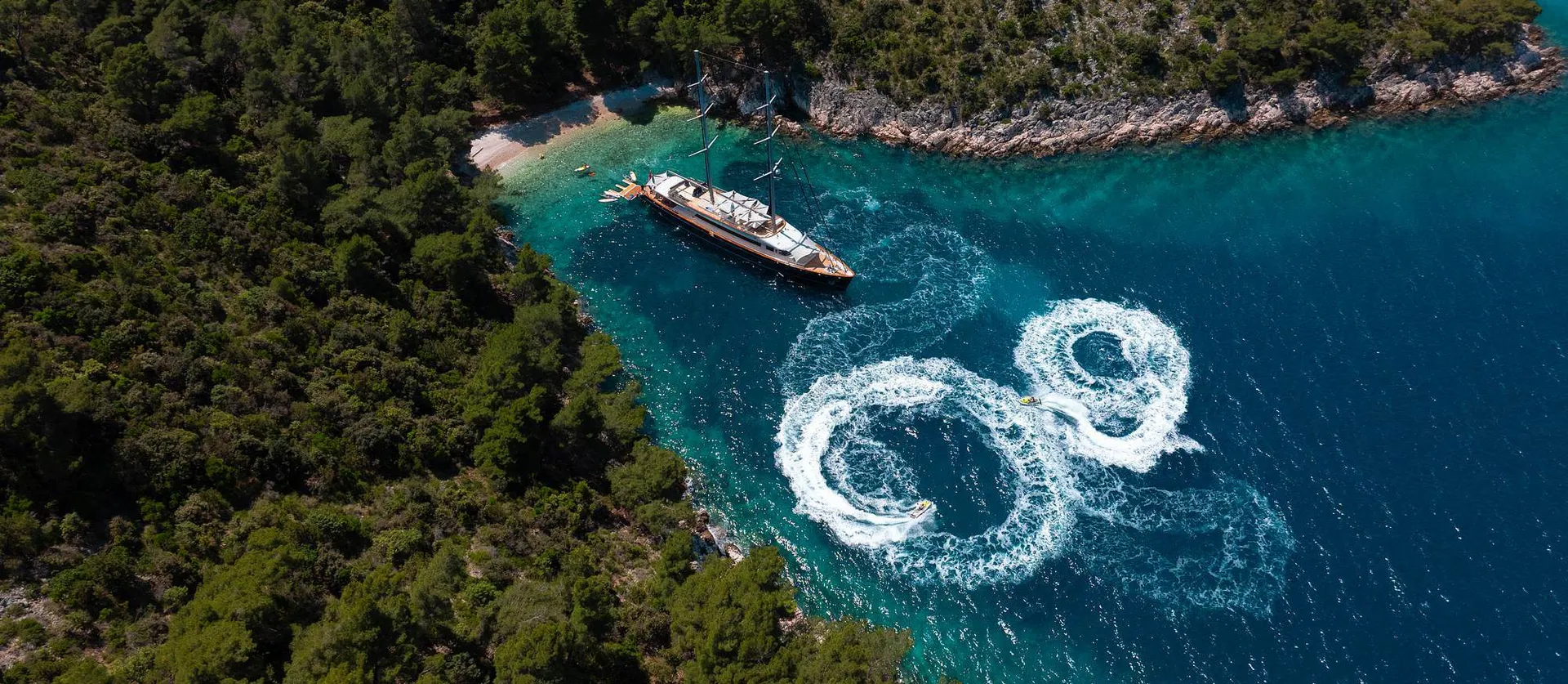 Die Dalmatino vor Anker in einer türkisen Bucht, von oben
