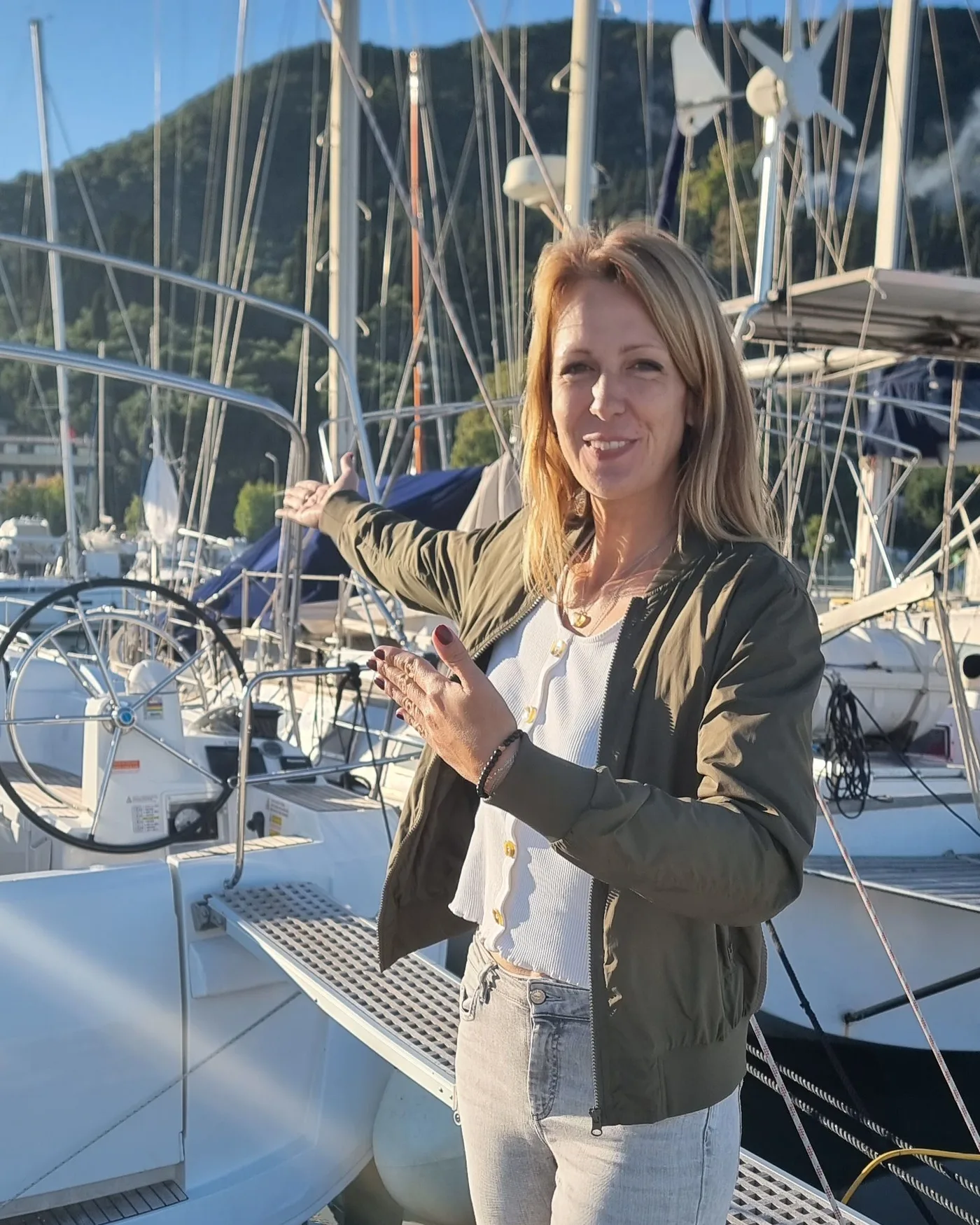 Laura zeigt in der Marina auf eine Charteryacht