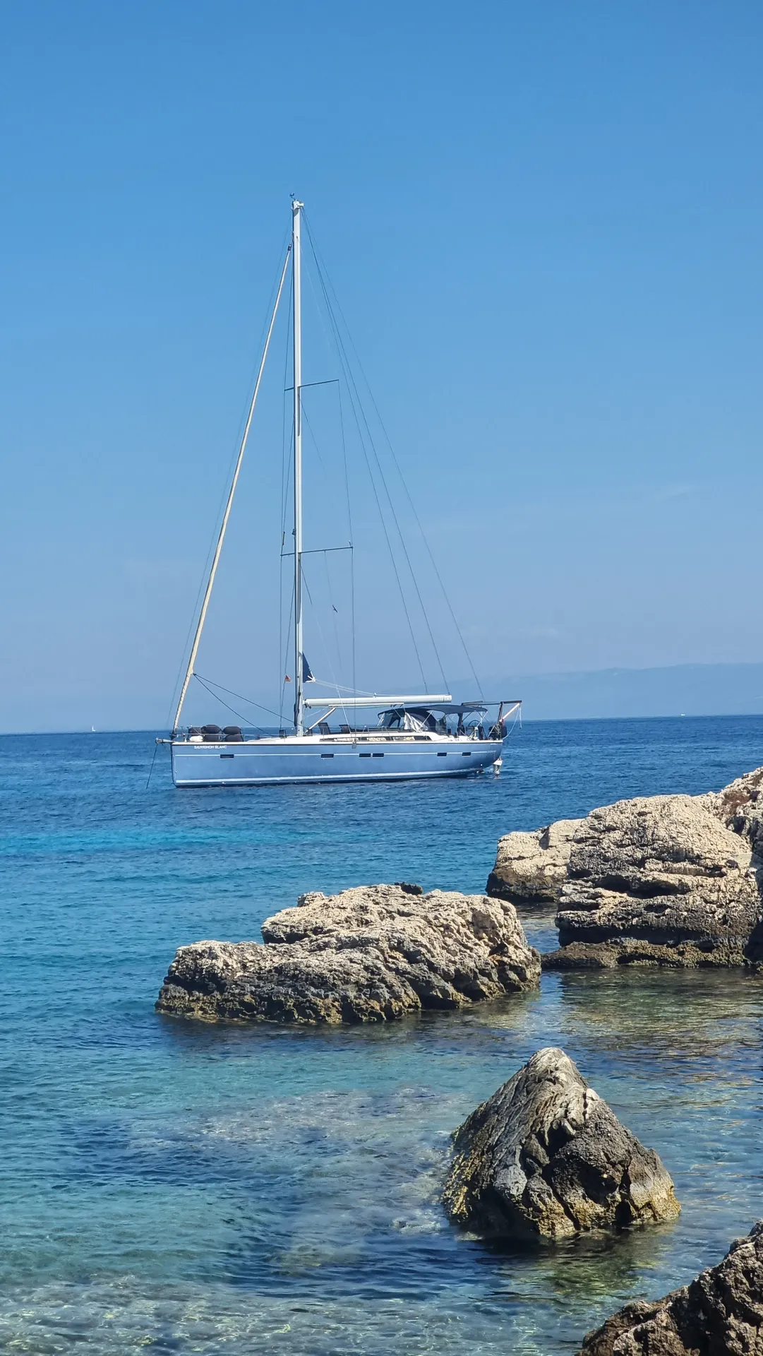 Die Sauvignon Blanc vor Anker zwischen Felsen in türkisem Wasser