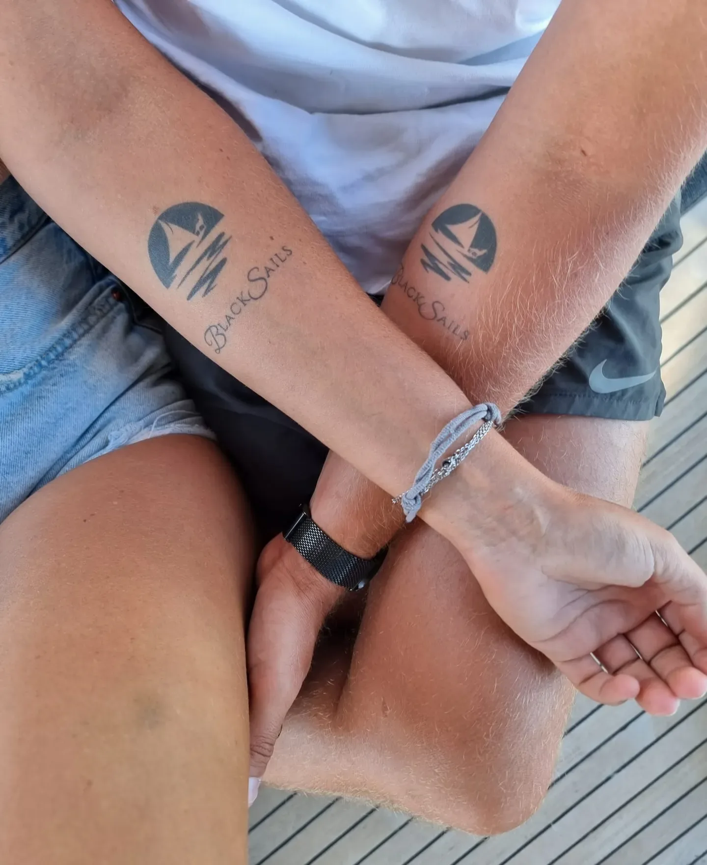 Zwei Unterarme mit dem Black-Sails-Logo als Tattoo