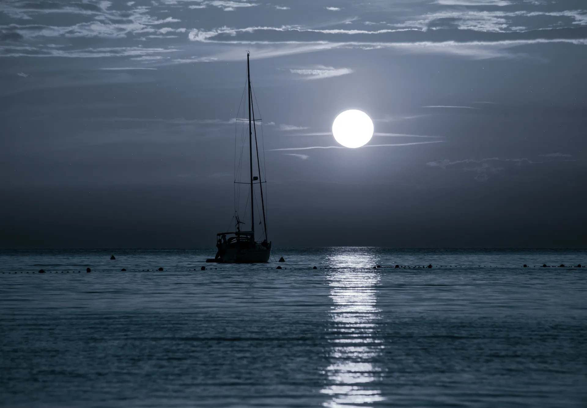 Segelyacht bei Vollmond auf dem Meer