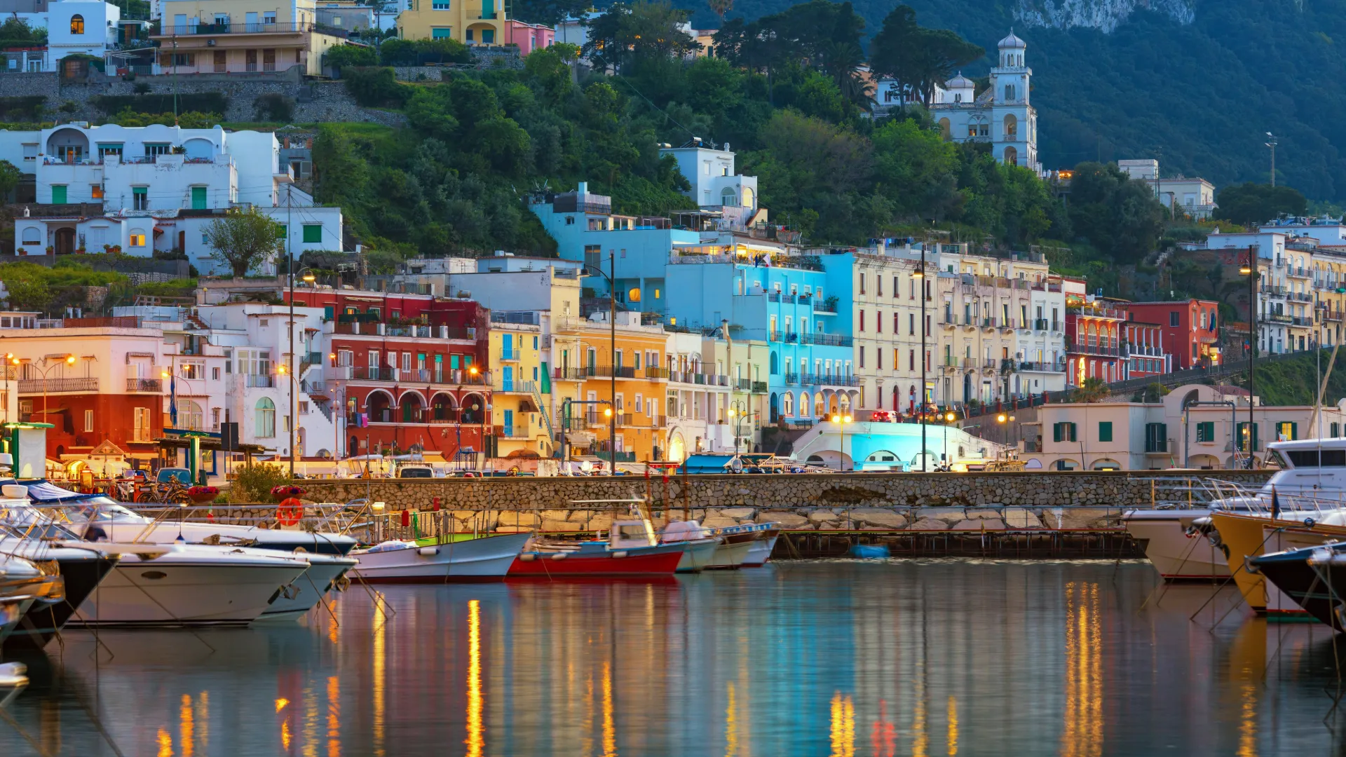 Blick auf den malerischen bunten Hafen von Capri – Segeln an der Amalfiküste mit pastellfarbenen Häusern und azurblauem Mee