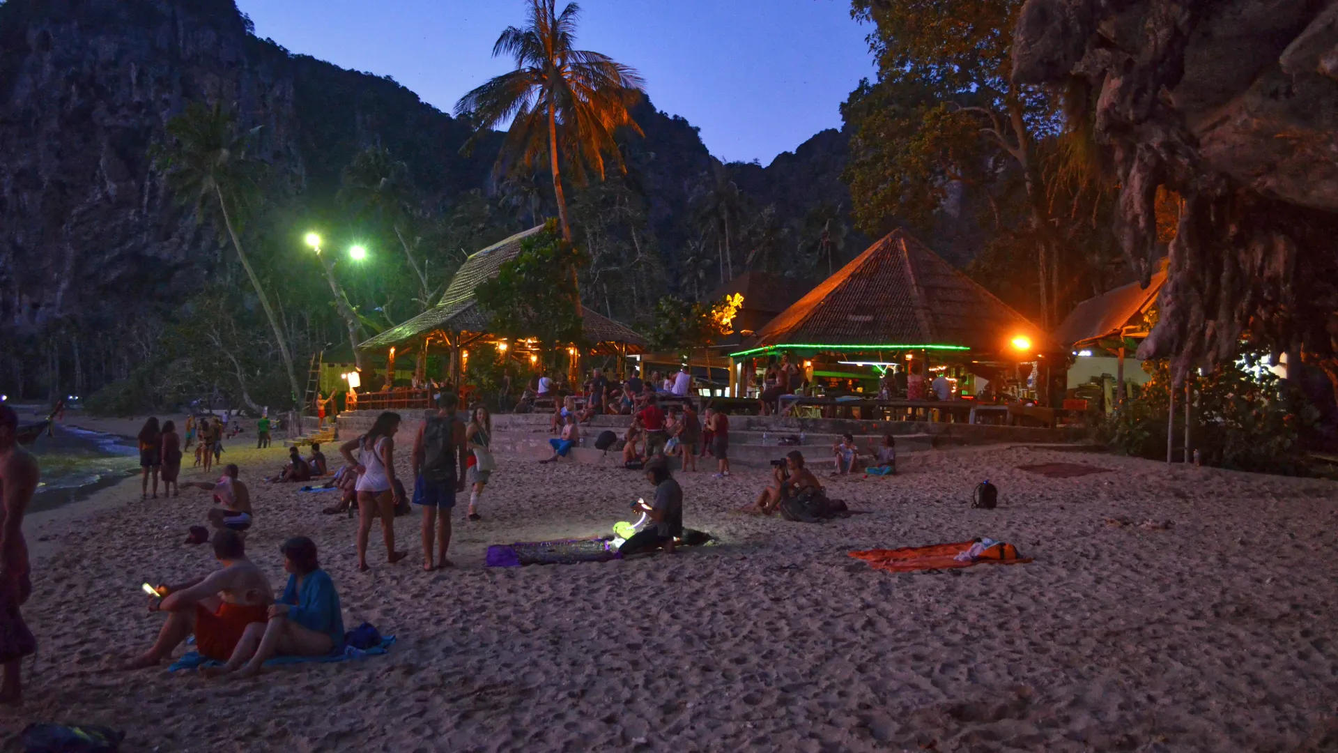 Lebhafter Strand in Thailand mit Restaurants und Bars direkt am türkisblauen Wasser – perfekte Mischung aus Entspannung und Unterhaltung.