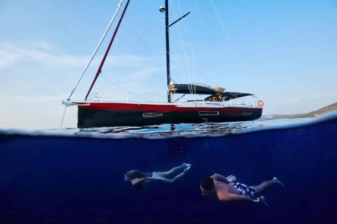 Zwei Schwimmer gleiten unter Wasser, während die Kabuki Yacht majestätisch auf der Oberfläche ruht – Freiheit über und unter den Wellen.