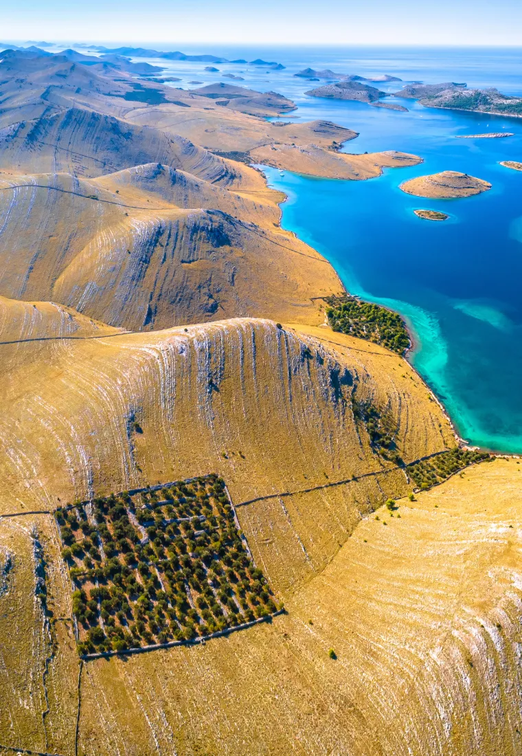 Luftaufnahme des Nationalparks Kornaten mit kargen Inselhügeln und türkisblauem Wasser