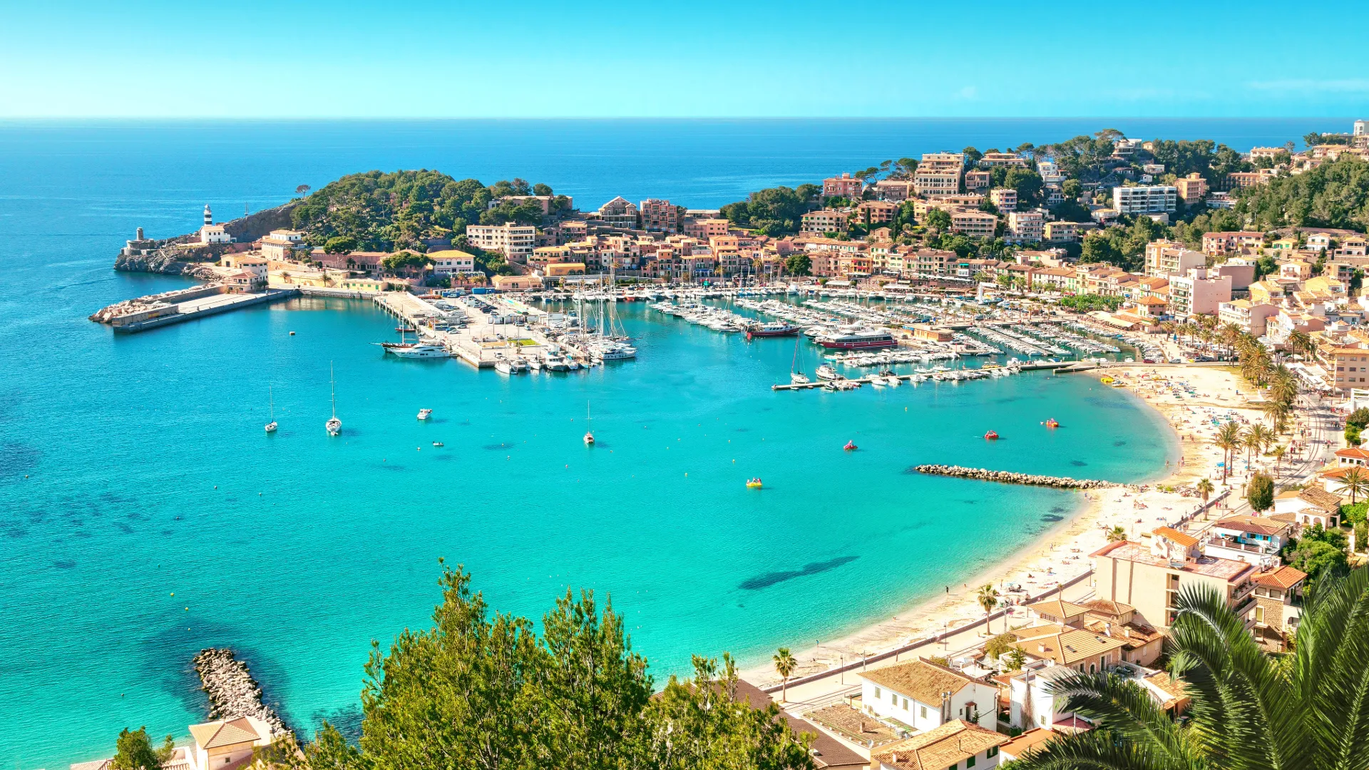 Blick auf den Hafen von Port de Sóller auf Mallorca mit türkisfarbenem Wasser und Yachten – ein Traumziel für Segler auf den Balearen