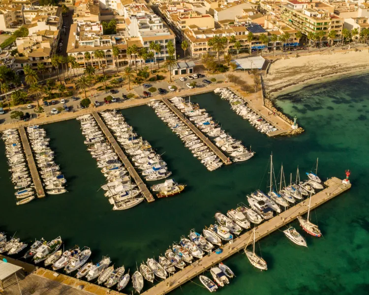 Luftaufnahme des Yachthafens von Colònia de Sant Jordi mit angrenzendem Stadtstrand und Promenade