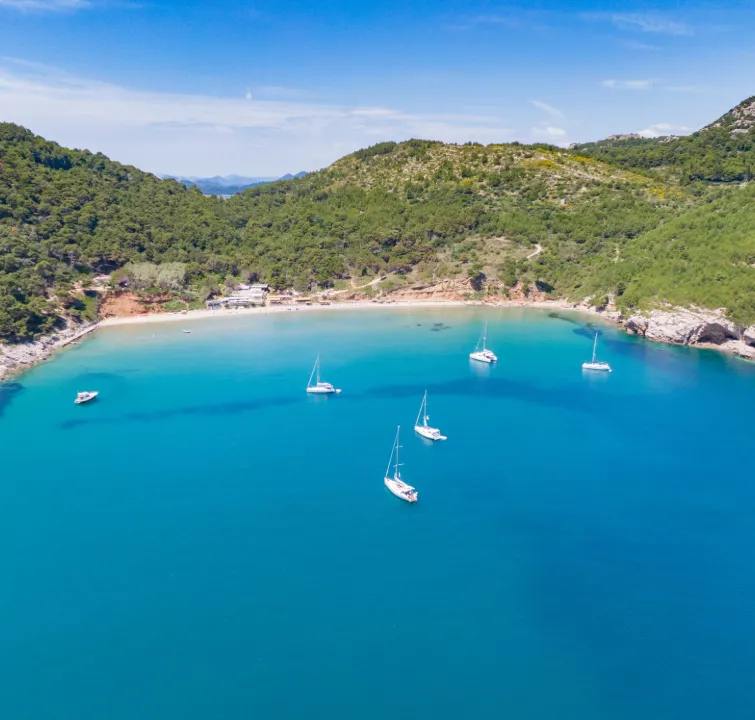 Segelboote vor Anker in der Šunj Bucht auf der Insel Lopud – Sandstrand und grüne Hügel beim Yachtcharter Süddalmatien mit BlackSails-Yachting