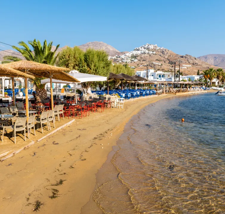 Strandpromenade von Livadi auf Serifos mit Tavernen, Sandstrand und Blick auf die Chora – Etappenziel beim Kykladen-Yachtcharter mit BlackSails-Yachting