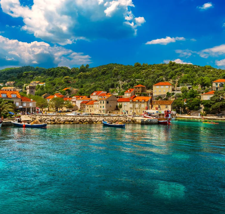 Traditionelle Steinhäuser und Boote in der Bucht Šipanska Luka auf der Insel Šipan – erste Station beim Segeltörn ab Dubrovnik mit BlackSails-Yachting