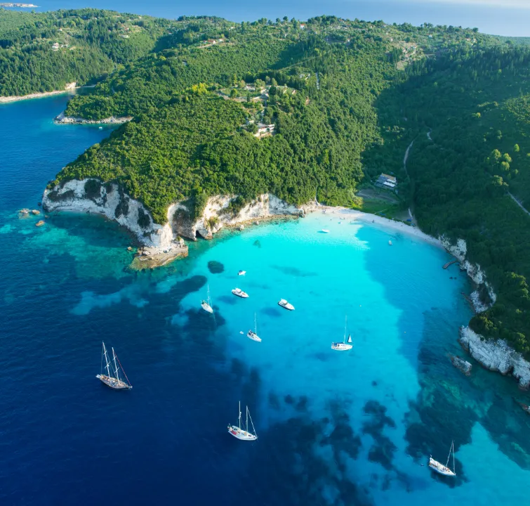 Segelyachten in einer türkisblauen Bucht an der Ostküste von Korfu – Yachtcharter-Erlebnis mit BlackSails-Yachting in Kalami oder Agni Bay