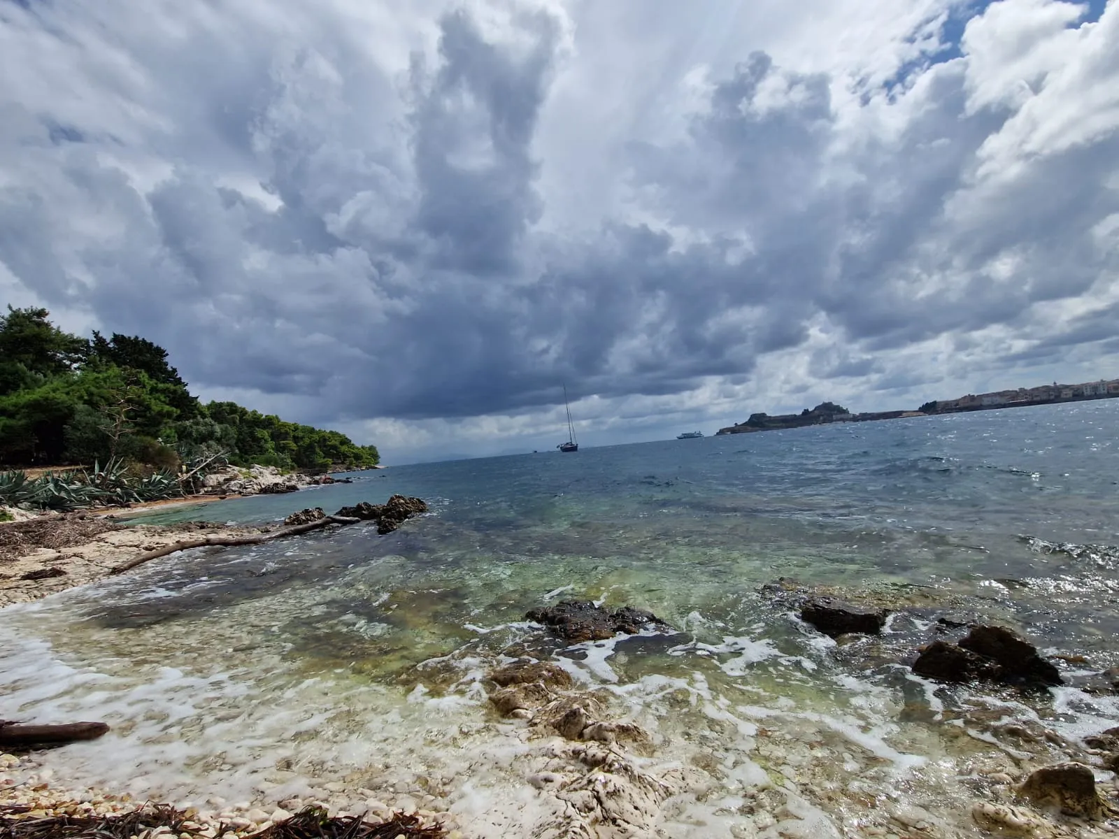 Segelyacht Sauvignon Blanc vor aufziehenden Gewitterwolken, fotografiert vom Strand